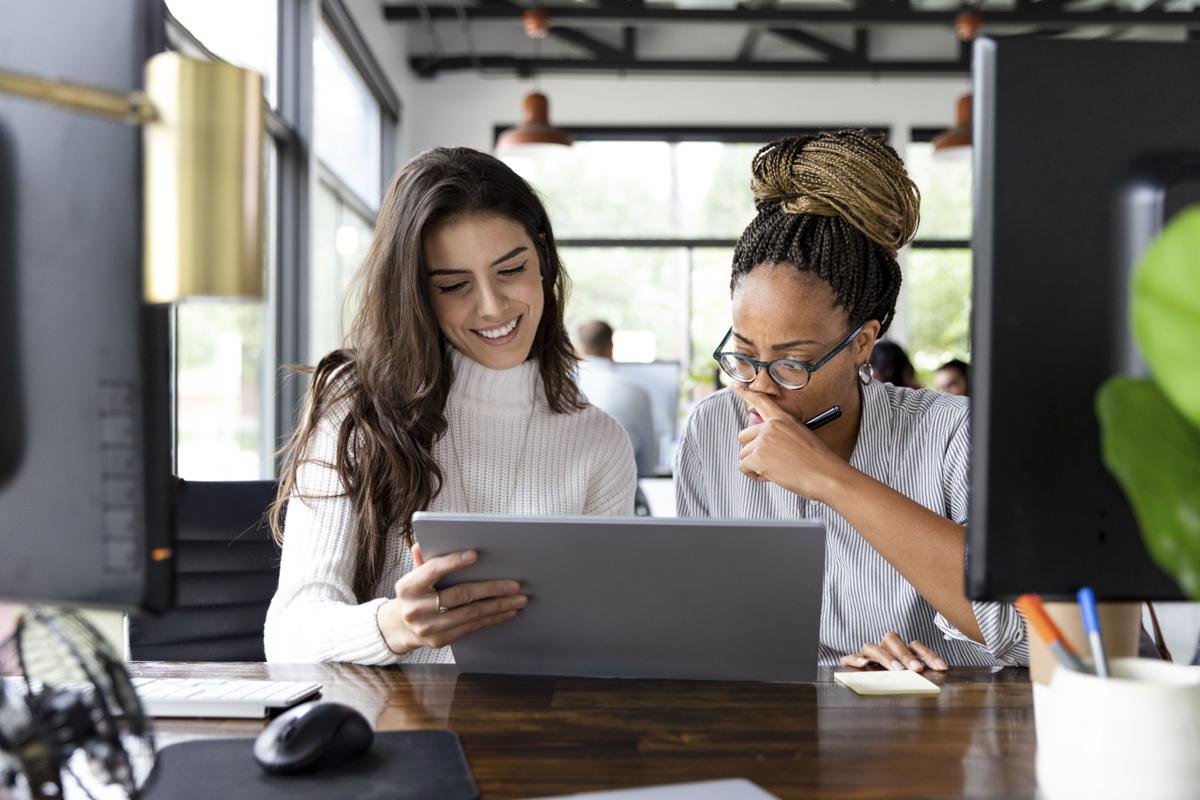 Two people collaborating in front of a laptop