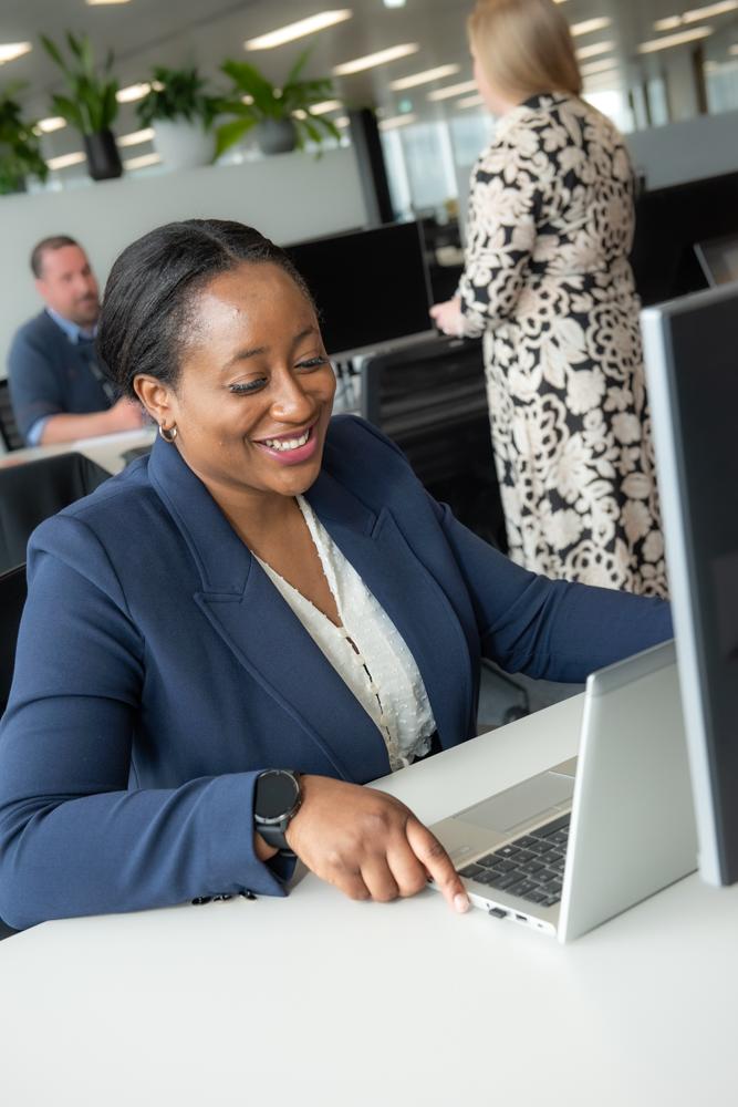 One of our colleagues smiling while working on her laptop